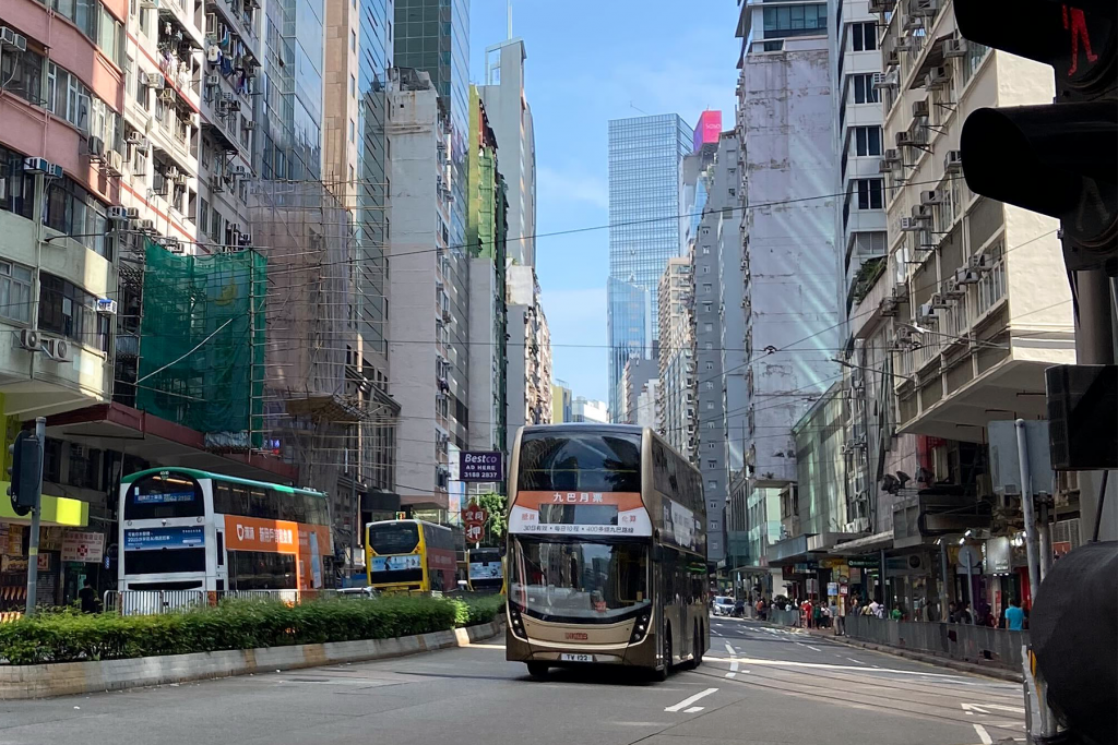 Double decker buses moving along an inner city rode in Asia.