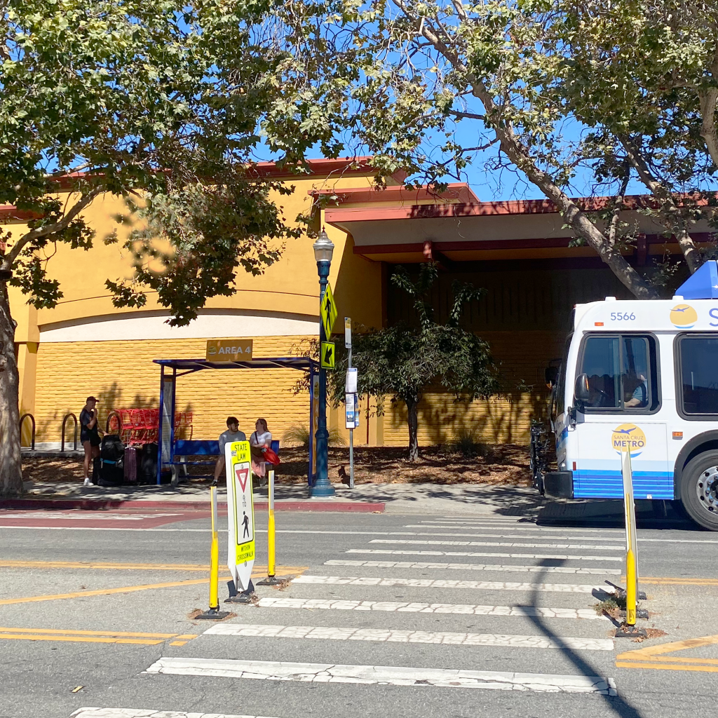 A clear safe crossing for pedestrians in front of a bus stop with shade and seating