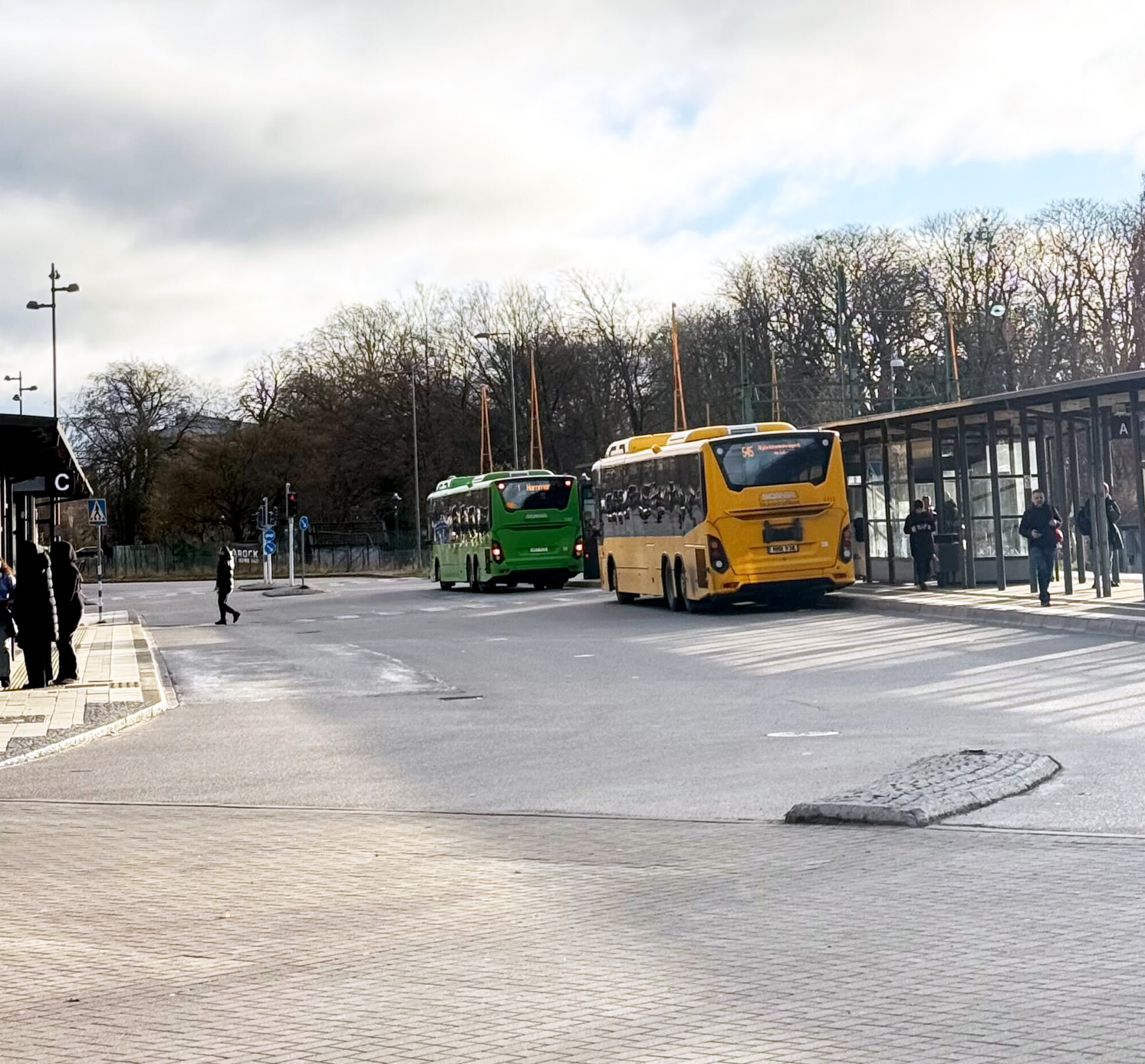 Local and regional color coded buses at a bus stop in Sweden