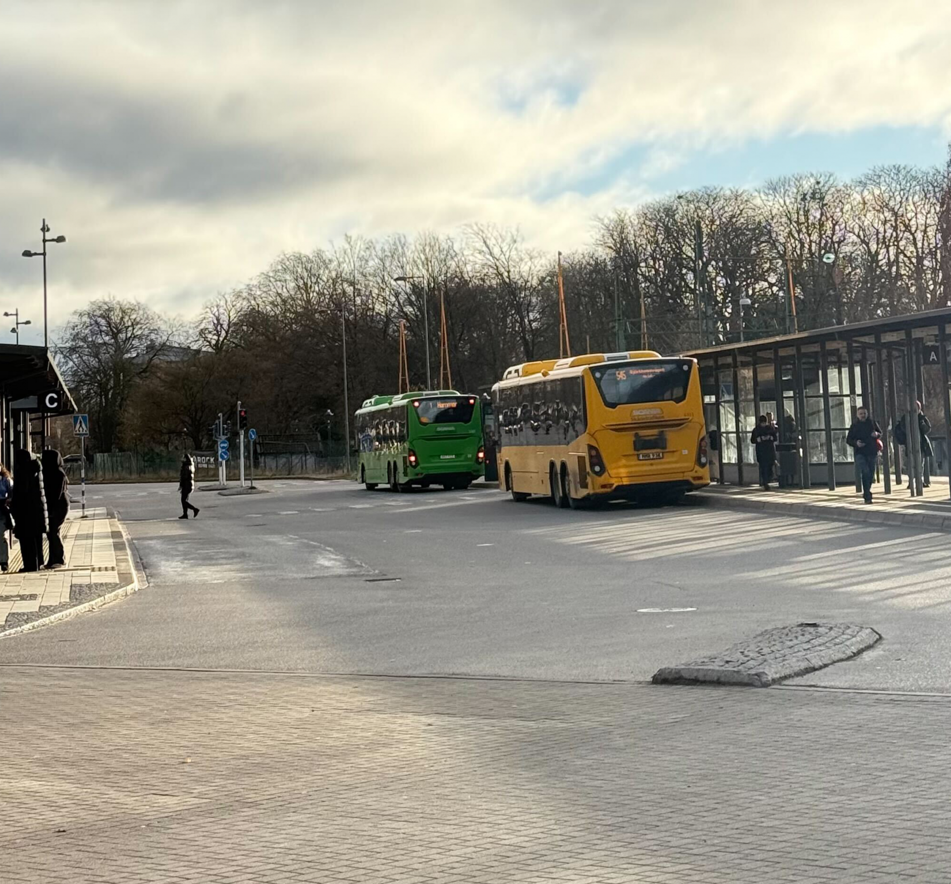 Local and regional color coded buses at a bus stop in Sweden